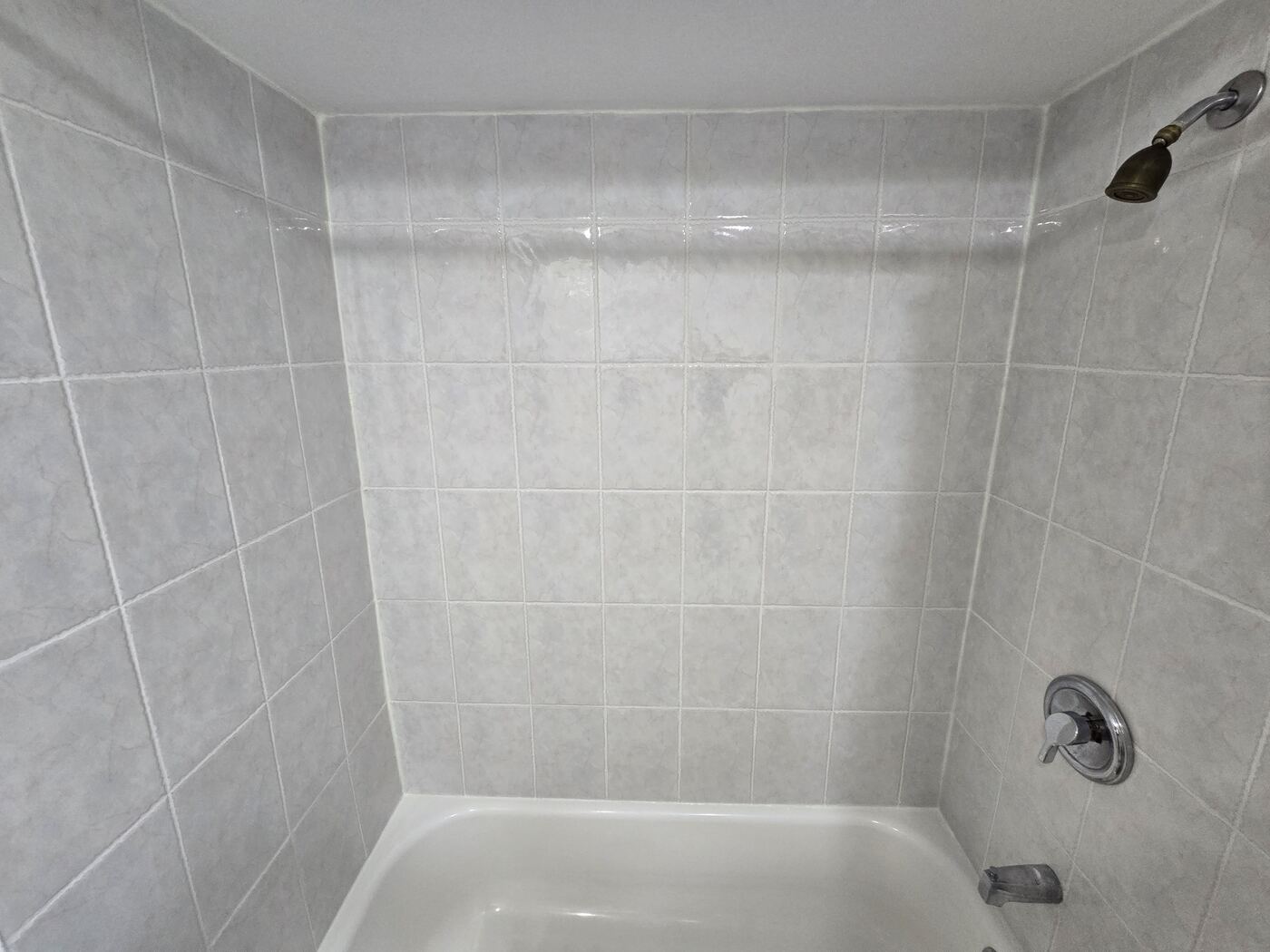After: the full tub surround with clean grout and fresh seals