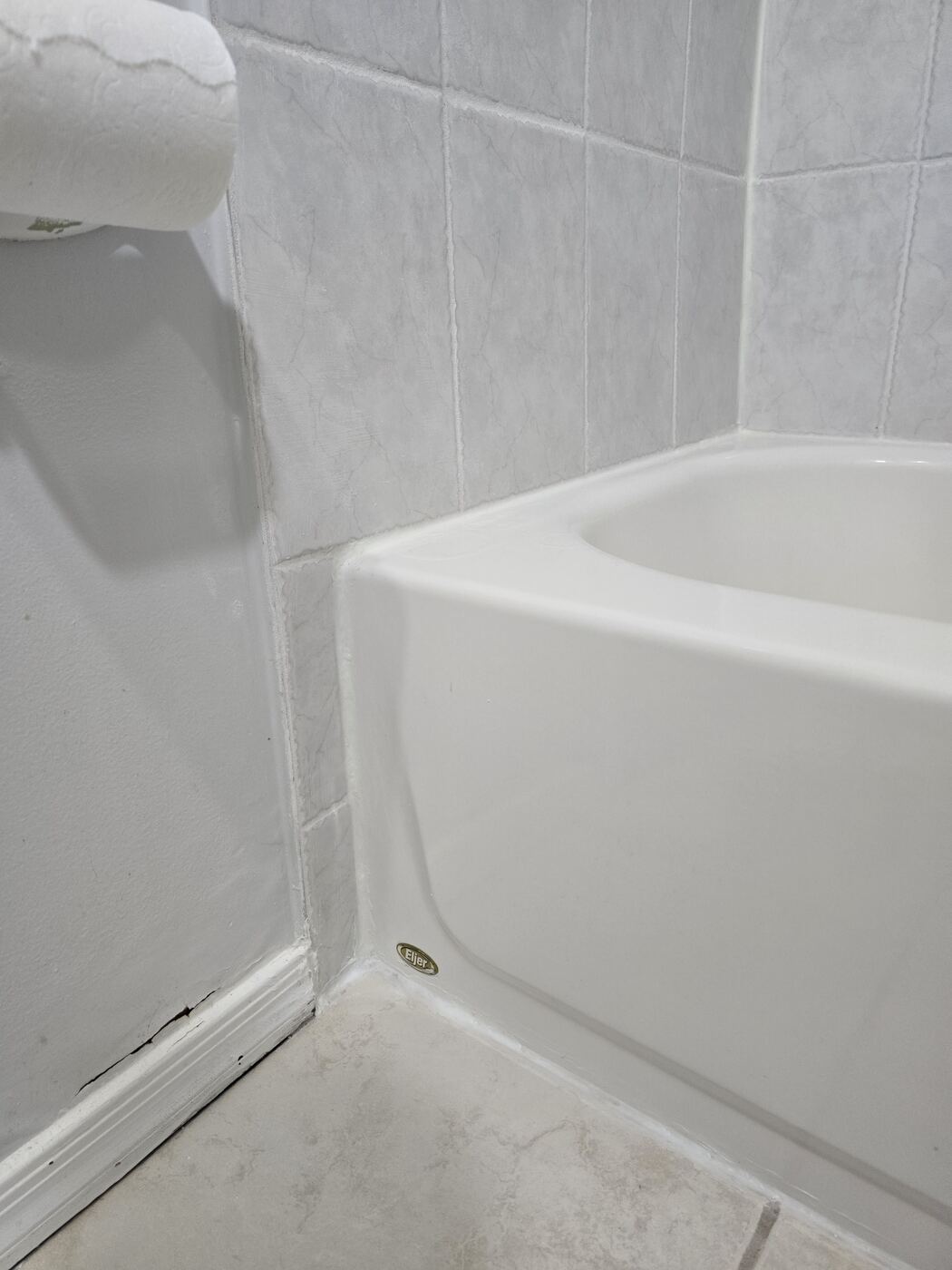 After: clean, sealed seam along the tub apron and wall