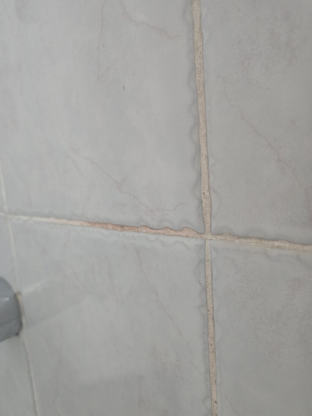Before: discolored, failing grout lines on the shower wall